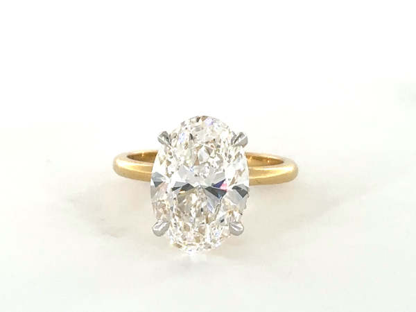 Oval ring with hidden halo set in diamond studded claws