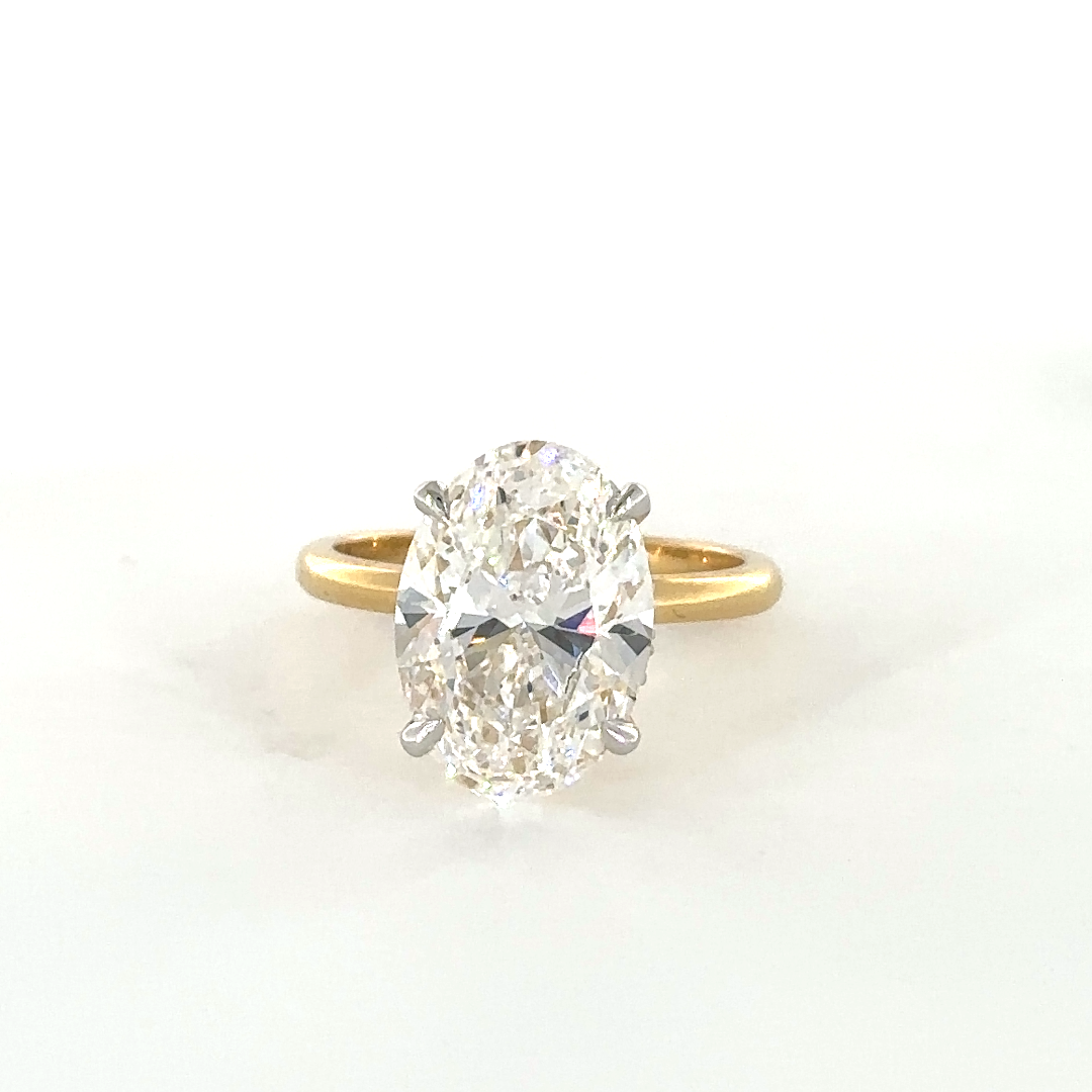 Oval ring with hidden halo set in diamond studded claws