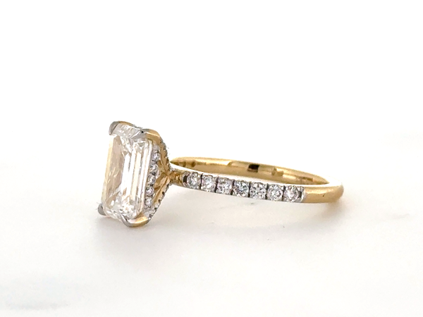 Emerald cut ring with hidden halo set in diamond studded claws and band